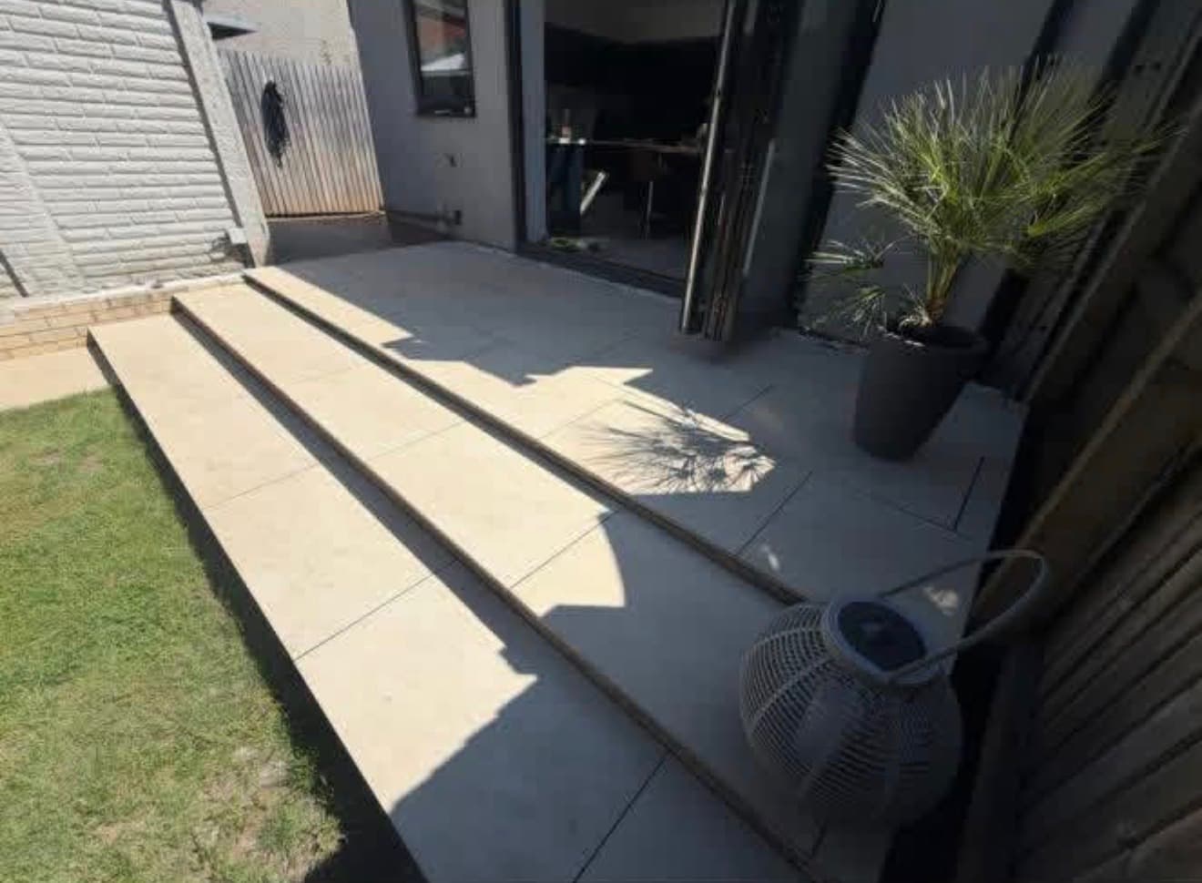 Porcelain patio with steps down to the lawn in Cardiff