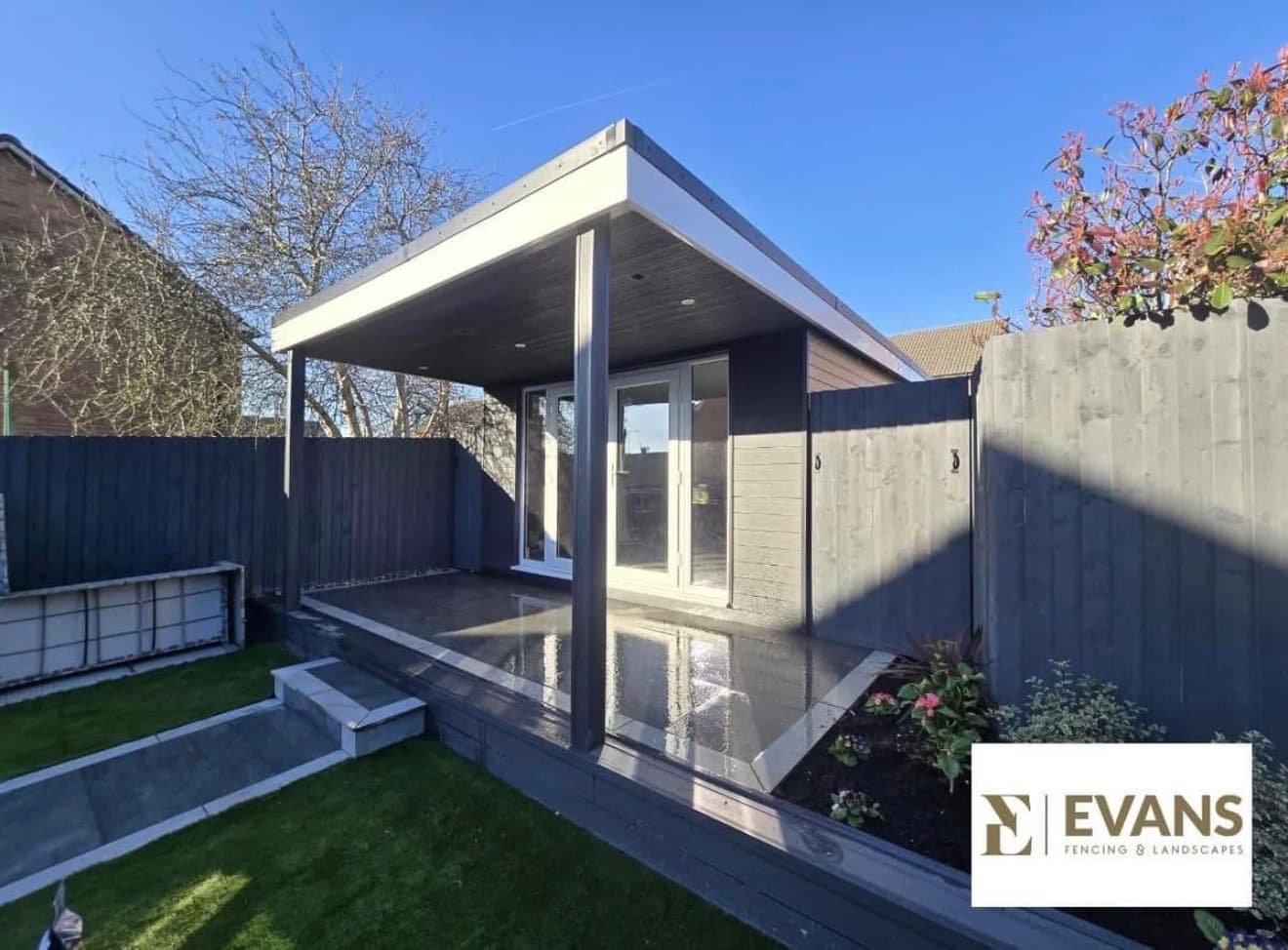Modern flat-roof garden room with paved patio and gravel garden by Evans Fencing & Landscapes