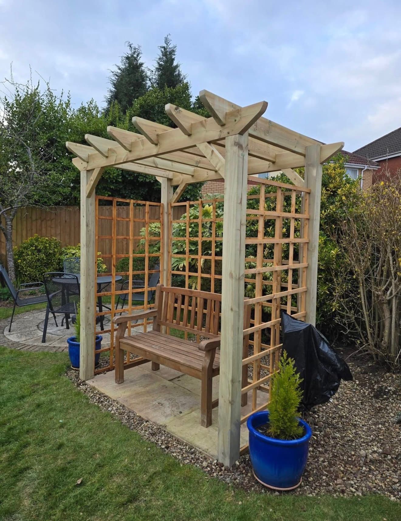 Timber pergola with trellis panels and bench seating